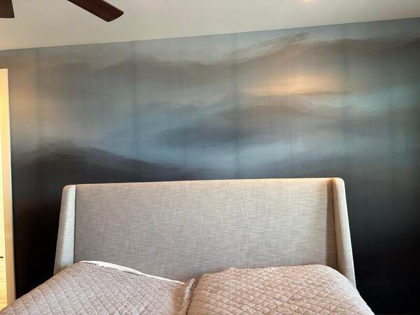 Mountain landscape mural wallpaper behind a bed in a Belton bedroom